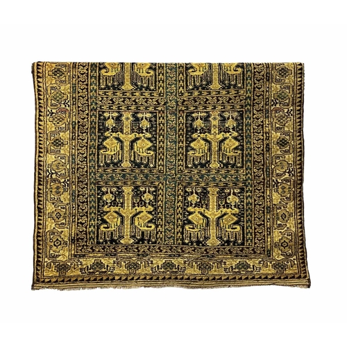 758 - An Afghan tribal rug, yellow ground, the eight square panels decorated with stylised motifs reserved... 