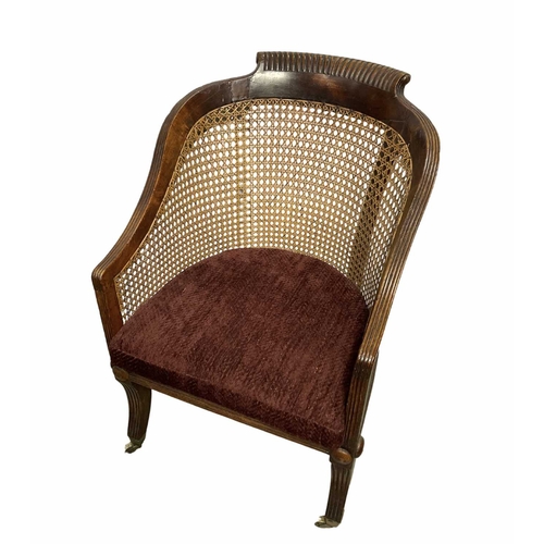 789 - A Regency bergere armchair with red covered squab cushion, multi convex reeding to edges on saber le... 