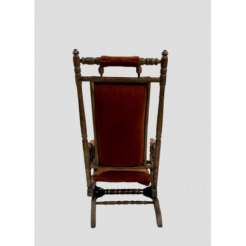 820 - A late 19th or early 20th century sprung rocking or steamer chair, with a light red velvet upholster... 