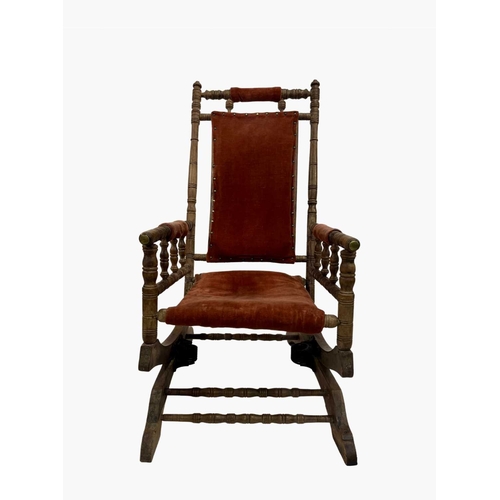 820 - A late 19th or early 20th century sprung rocking or steamer chair, with a light red velvet upholster... 