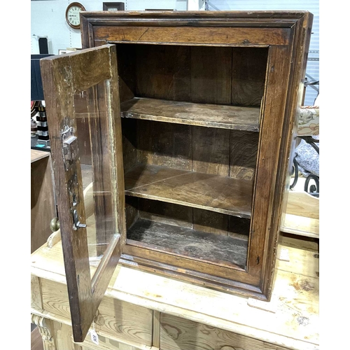 827 - A traditional fruitwood cupboard with moulded border single glazed door opening to fixed shelving, 7... 