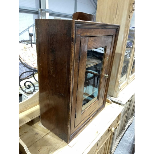 827 - A traditional fruitwood cupboard with moulded border single glazed door opening to fixed shelving, 7... 