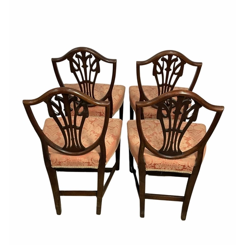 836 - A set of four Georgian mahogany shield-back dining chairs carved with the Prince of Wales feathers, ... 