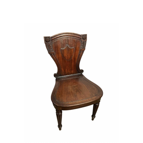 840 - A 19th century mahogany hall chair, scrolled shield back with central cartouche, bordered by stylise... 