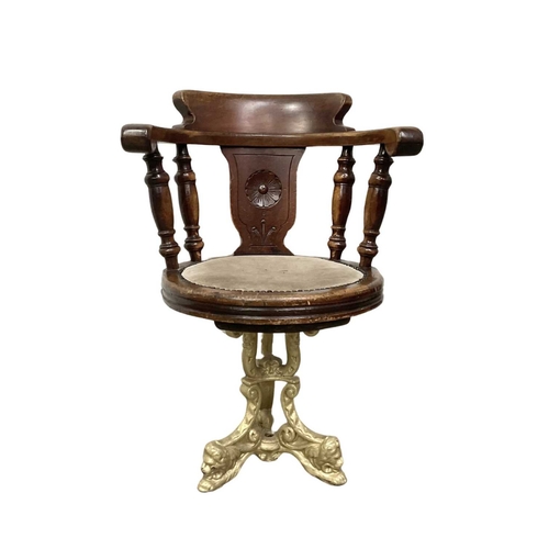 843 - A mahogany swivel desk chair, late 19th century, the splat carved with a rosette, close nailed suede... 