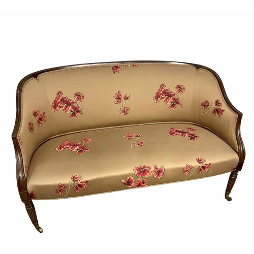 852 - Small mahogany framed salon sofa, possibly French, reeded legs on brass casters, covered in a floral... 