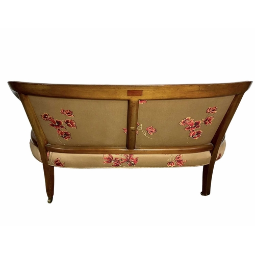 852 - Small mahogany framed salon sofa, possibly French, reeded legs on brass casters, covered in a floral... 