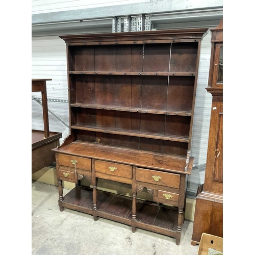 858 - A George III oak dresser and rack, circa 1760, the three bay base of short drawers with swan neck br... 