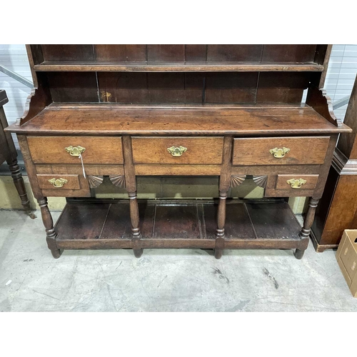 858 - A George III oak dresser and rack, circa 1760, the three bay base of short drawers with swan neck br... 