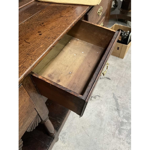 858 - A George III oak dresser and rack, circa 1760, the three bay base of short drawers with swan neck br... 