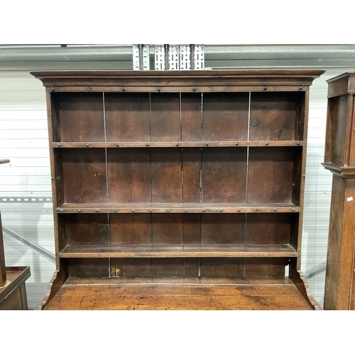 858 - A George III oak dresser and rack, circa 1760, the three bay base of short drawers with swan neck br... 