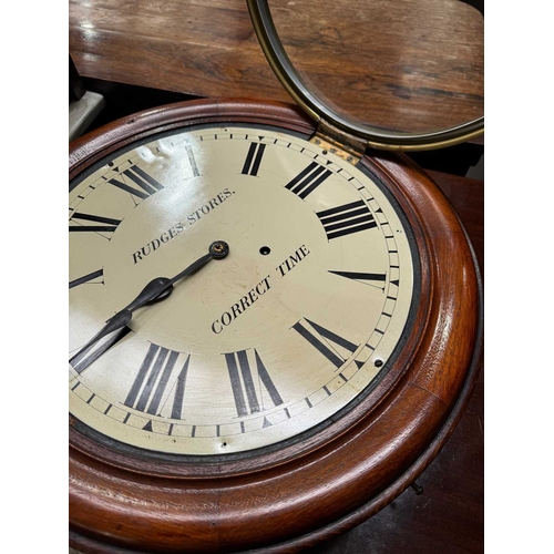 867 - A 19th century 'Rudges Stores' wall-mounted clock, circular mahogany cushion frame with brass casing... 