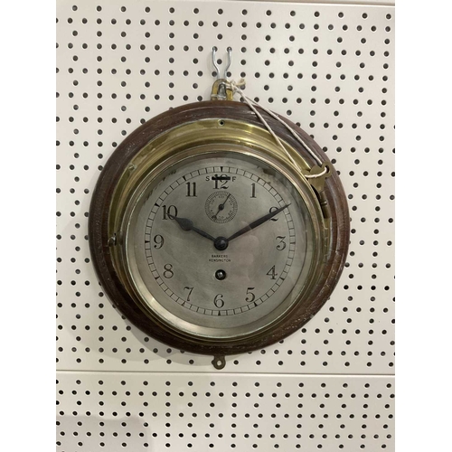 870 - A brass cased ship's wall clock by Barkers of Kensington, hinged glass cover over a silvered dial wi... 