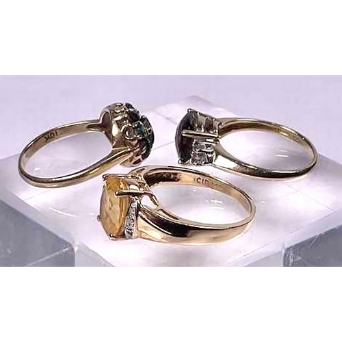 617 - Two gold coloured metal quartz dress rings, together with a gold coloured metal green gem cluster ri... 