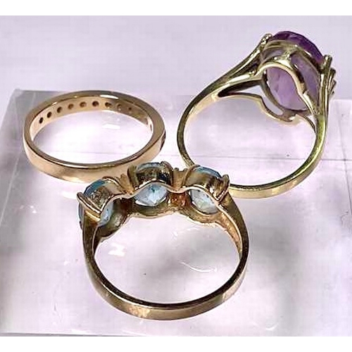 625 - Three gold coloured metal gem-set rings, to include a blue topaz three-stone ring, an amethyst singl... 