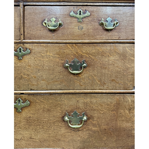 829 - An 18th-century oak chest of drawers, two short drawers over three long with brass drop handles and ... 