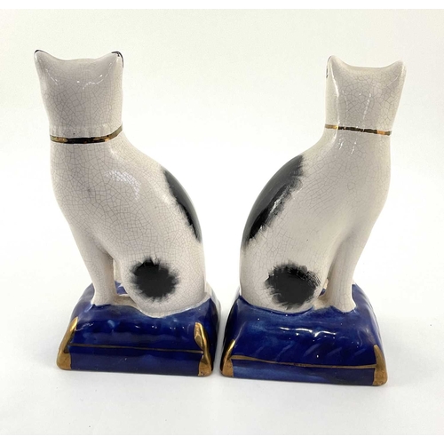 100 - A pair of small Staffordshire type cats on cushions, crackle glaze through, painted, gilt detailing,... 