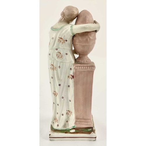 117 - A c.1800 pearlware figure on a square base modelled as Andromache standing beside a plinth on which ... 