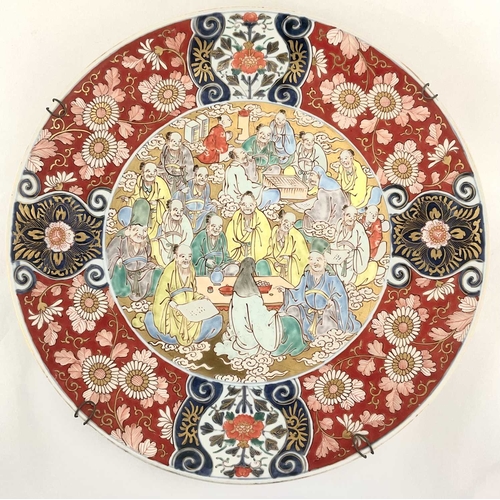 120 - A Japanese Imari charger, Meiji period, the centre painted with figures in attendence reserved again... 