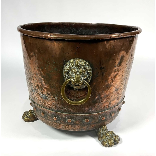 208 - A 19th century copper and brass log bin with lion mask handles to sides, riveted base and paw feet (... 