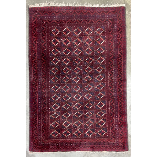 337 - A red ground Afghan Baluch-type wool rug, approx 175cm long, 122cm (1)