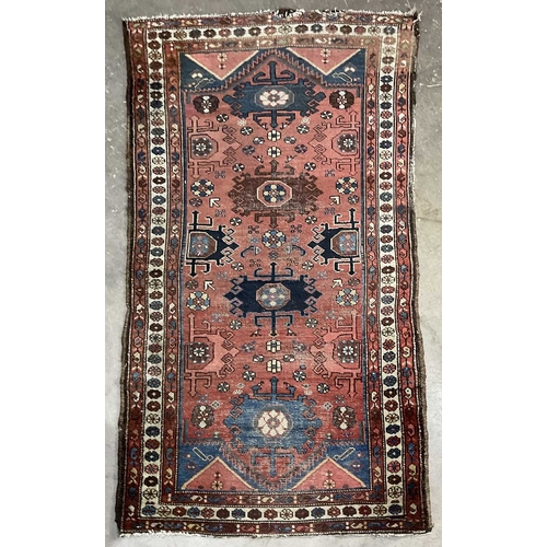 349 - A tribal, likely Afghani rug, blue geometric floral shapes on red ground with white boarder, approx ... 