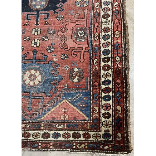 349 - A tribal, likely Afghani rug, blue geometric floral shapes on red ground with white boarder, approx ... 