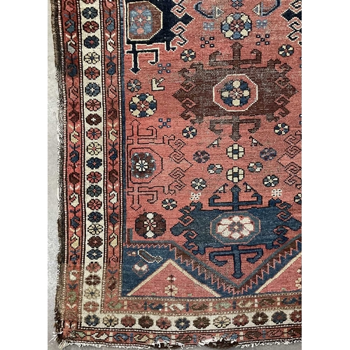 349 - A tribal, likely Afghani rug, blue geometric floral shapes on red ground with white boarder, approx ... 