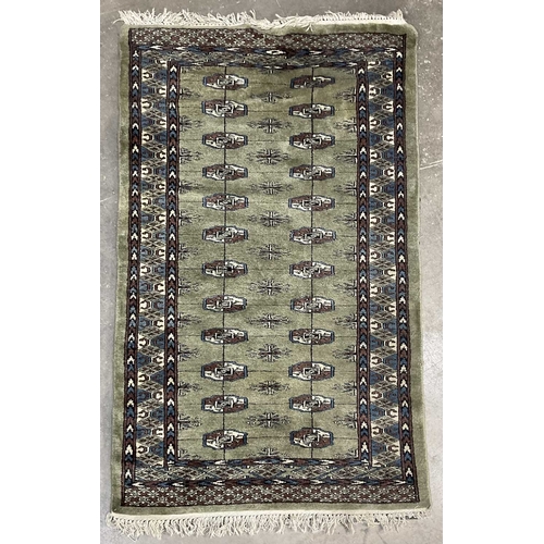 350 - A green ground wool rug with brown and blue geometric shapes, approx 160cm long, 93cm wide (1)