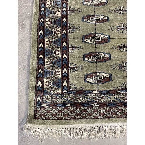 350 - A green ground wool rug with brown and blue geometric shapes, approx 160cm long, 93cm wide (1)