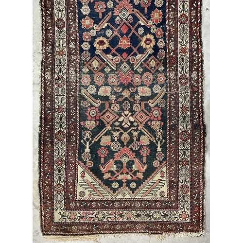 351 - A brown, red and navy runner, central rectangle section decorated with floriated forms, approx 315cm... 