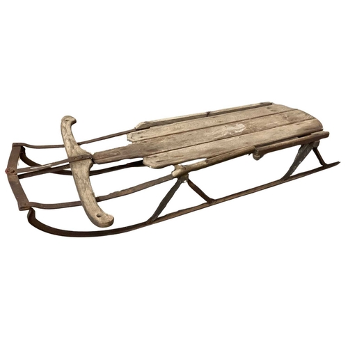 351A - Carved wood sledge or toboggan with wrought iron frame, late 19th/early 20th, 123cm long, 63cm wide ... 