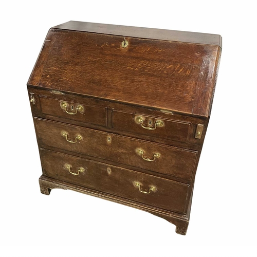 369 - A late 18th or early 19th century oak bureau, fall front opening to a gallery of graduated small com... 