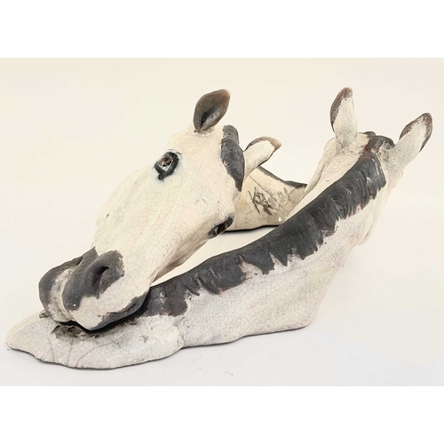 94 - Keza Rudge (British, 20th century), model of two intertwined horse heads, slip cast raku, signed to ... 