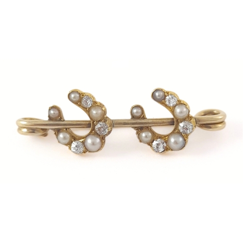 303 - An early 20th century gold pearl and diamond double horseshoe brooch