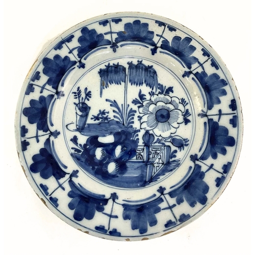 130 - A Dutch Delft plate, first half 18th century, painted in underglaze blue with flowering branches, th... 