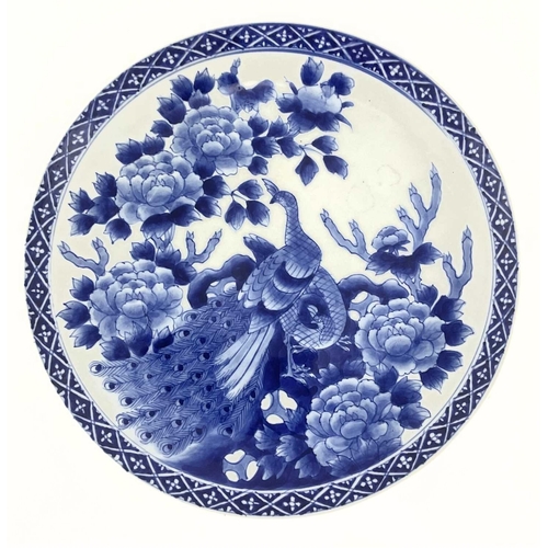 138 - A Japanese blue and white charger, Meiji period, circa 1900, painted with a peacock amongst rockwork... 