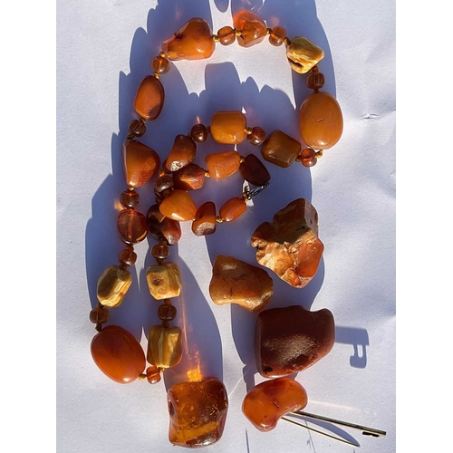 312 - A selection of amber items, to include a bead necklace, loose amber and a brooch, total weight appro... 