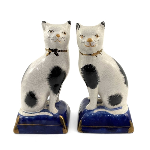 100 - A pair of small Staffordshire type cats on cushions, crackle glaze through, painted, gilt detailing,... 