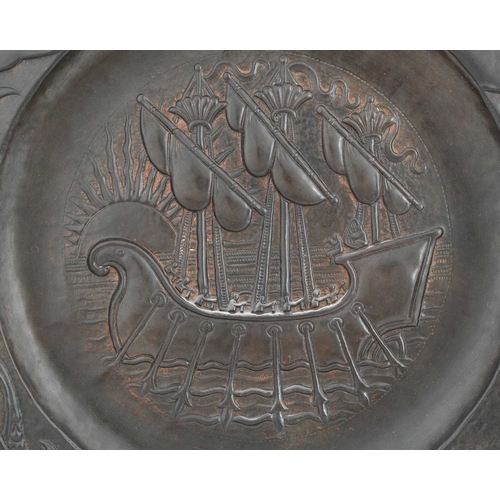 16 - John Pearson, an Arts and Crafts copper charger, 1895, wide brimmed circular form, repousse embossed... 