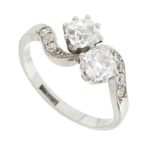 140 - An Art Deco platinum old-cut diamond two-stone crossover ring, with similarly-cut diamond asymmetric... 