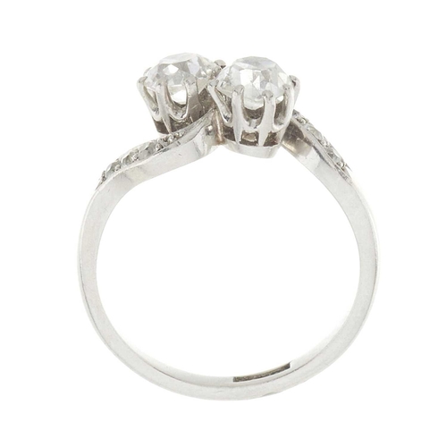 140 - An Art Deco platinum old-cut diamond two-stone crossover ring, with similarly-cut diamond asymmetric... 