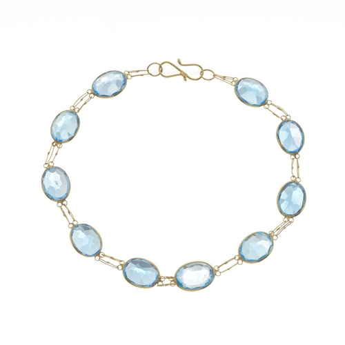 230 - A 14ct gold oval-shape blue topaz line bracelet, with S hook clasp, stamped 585, length 17cm, 4g