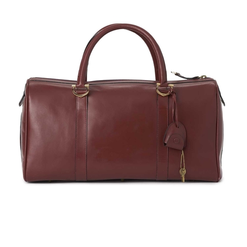 352 - Cartier, a large Bordeaux Must De Cartier Boston travel bag, crafted from burgundy leather, with gol... 