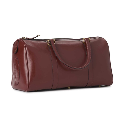 352 - Cartier, a large Bordeaux Must De Cartier Boston travel bag, crafted from burgundy leather, with gol... 