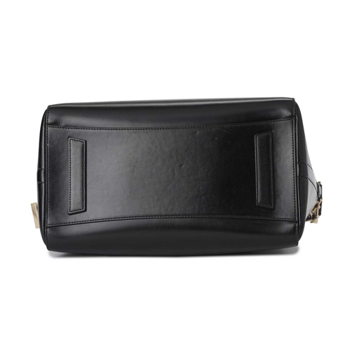 412 - Givenchy, an Antigona handbag, designed with a smooth black leather exterior, with a triangular patc... 