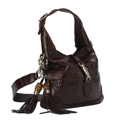 424 - Gucci, a crocodile Jackie shoulder bag, crafted from luxurious brown crocodile skin, featuring gold-... 