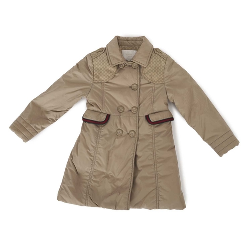 427 - Gucci, a child's coat, featuring a beige nylon shell, red and green striped trim, double-breasted fr... 