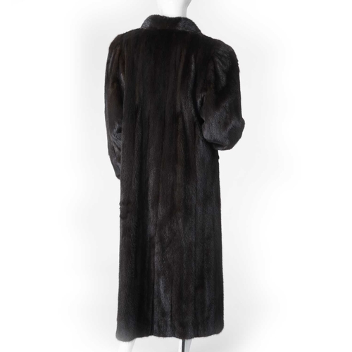 555 - A full-length dark ranch mink coat, fully stranded, with a short lapel collar, barrel sleeves with f... 