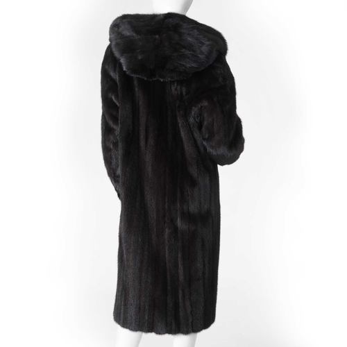 560 - A hooded dark ranch mink coat, designed with a large fur-lined hood, double hook and eye clip fasten... 